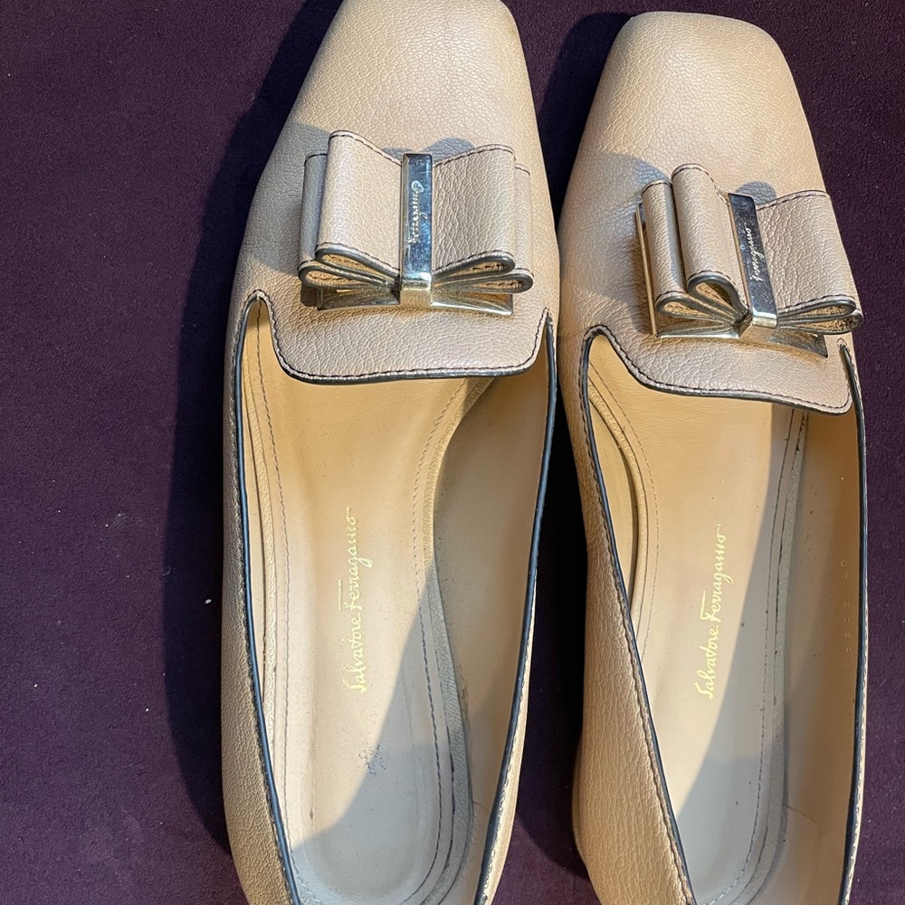 Salvatore Ferragamo nude heels with signature bow on with gold hardware on it